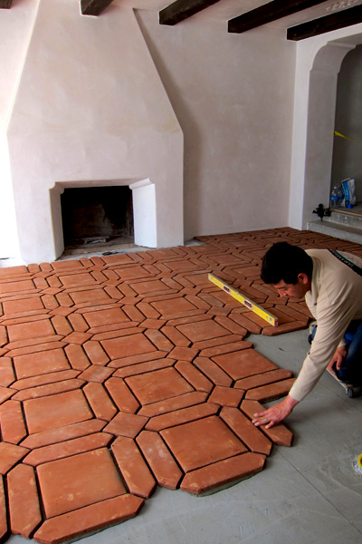 a Tile Setter in Montecito California Installing a Squares Pickets Design Clay Floor Tile in Front of a Spanish Colonial Revival Style Fireplace in a Spanish Home Remodel