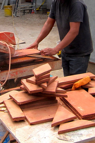 a Santa Barbara California Tile Setter Uses a Wet Saw to Cut Terra Cotta Floor Tiles into Narrow Strips for a Herringbone Floor Being Installed in a Montecito California Spanish Style Home