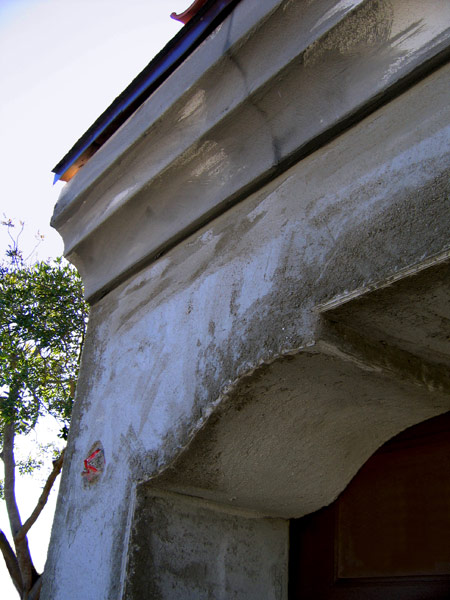 Close up photo of Spanish style exterior plaster coving being installed during the construction process. A thick corbel detail in the corner of the garage door opening of this Jeff Doubét designed home in Santa Barbara, California.