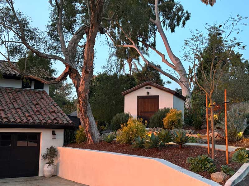 A spanish style accessory structure and beautiful santa barbara landscape above a four foot stucco wall